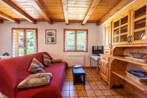 a living room with a red couch and a table at Chalet de la Marmotte in Crest-Voland