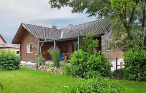 a wooden house with a fence and a yard at Entenhaus in Hilgendorf