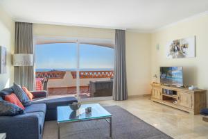 a living room with a couch and a tv at Astonishing view modern apartment in Sitio de Calahonda