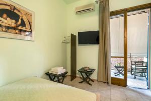 a bedroom with a bed and a tv and a balcony at Old Boat double studio 2 in Nikiana