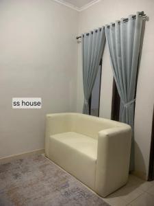 a white couch in a room with a window at SS house in Tabanan