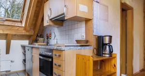 a small kitchen with wooden cabinets and a stove at Ferienwohnung Pfisterhof in Kirchzarten