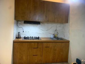 a kitchen with wooden cabinets and a stove top oven at SS house in Tabanan