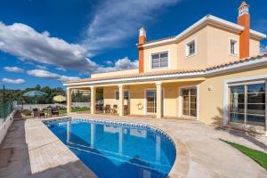 a house with a swimming pool in front of it at Villa Alvor in Alvor