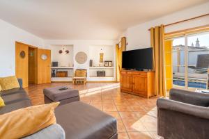 a living room with a couch and a flat screen tv at Villa Alvor in Alvor