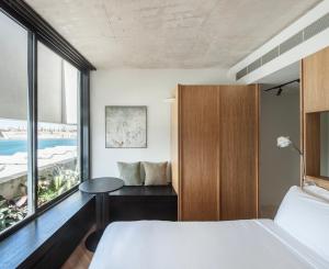 a bedroom with a bed and a table and a window at Stilla, San Mikiel in Senglea