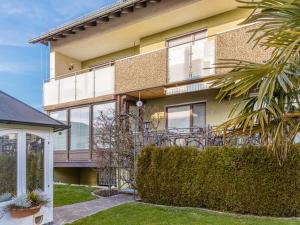 a large yellow house with windows and a bush at Comfort Apartment Buchhorn in Friedrichshafen