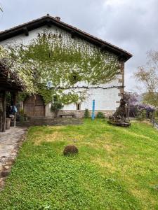 a building with ivy growing on the side of it at Iregi Natura Casa Rural in Oskotz