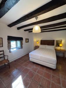 a bedroom with a bed and a table and a chair at Iregi Natura Casa Rural in Oskotz