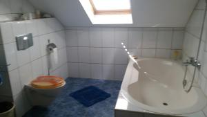 a bathroom with a tub and a toilet and a sink at Ferienwohnung Karin in Eltmann +6 photos