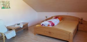 a bedroom with a wooden bed and a table at Ferienwohnung Karin in Eltmann