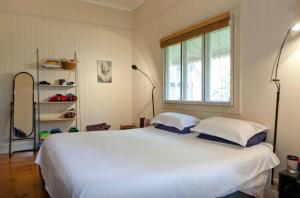 een slaapkamer met een groot wit bed met 2 kussens bij Green Gables in Brisbane