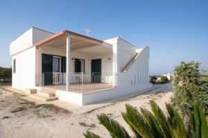 ein weißes Haus mit Veranda am Strand in der Unterkunft Muma House in Otranto