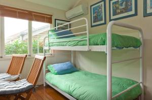 een kamer met 2 stapelbedden en een stoel bij Green Gables in Brisbane