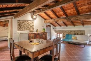 a dining room with a wooden table and a couch at Casale di Polly in Garfagnana in Minucciano +31 photos