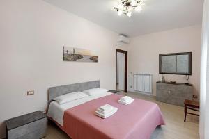 a bedroom with a large bed with a pink blanket at Casa Vacanza Anni' in Vico Equense