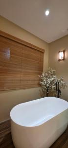 a large white bath tub in a room with a window at Ipoh Town Hotel by Serenity in Ipoh