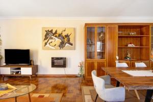 a living room with a table and a television at Villa da Floresta in Arcos