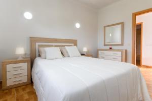 a white bedroom with a large white bed and a mirror at Apartamento Ye in Haría