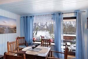 a dining room with a table and a large window at Mole Valley Ranch Fewo2 in Elmlohe