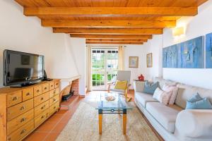 a living room with a couch and a tv at Casa de praia na costa da Galé in Melides
