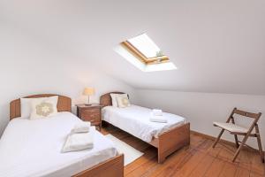 a bedroom with two beds and a skylight at Casa de praia na costa da Galé in Melides