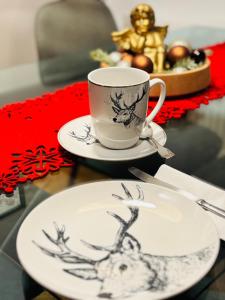a plate and a coffee cup on a table at Mmapartment in Feistritz ob Bleiburg +32 photos