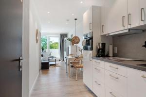 a kitchen with white cabinets and a dining room at Ferienappartement Holm Ostsee in Brasilien