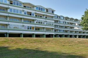 a large building on top of a grassy hill at Ferienappartement Holm Ostsee in Brasilien