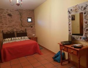 a bedroom with a red bed and a mirror at Mansió De La Plata in Peñacaballera +10 photos