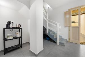a white room with a staircase and a shelf at Casa Vacanze Sa Domixedda in Guspini