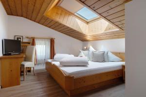 a bedroom with a large bed with a skylight at Kristiania Apartement Typ B in Siusi