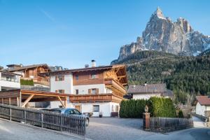 a building with a mountain in the background at Kristiania Apartement Typ B in Siusi