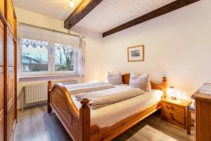 a bedroom with a wooden bed and a window at Ferienwohnungen Sterdebüll-Hof in Bordelum