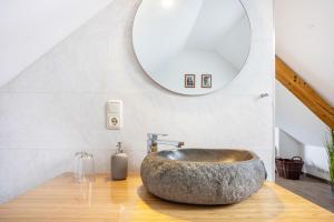 a bathroom with a large stone sink and a mirror at Apfelhof Maurer in Lindau +51 photos