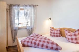 a bedroom with a bed with pillows and a window at Appartement Julia in Achenkirch