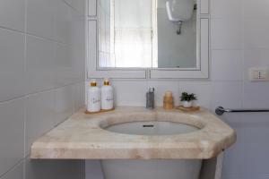 a bathroom sink with two soap bottles on it at Casa Loretta 3 in Valledoria +18 photos