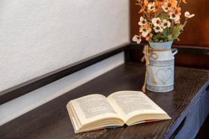 an open book on a table with a vase of flowers at Casa Loretta 3 in Valledoria