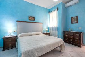 a blue bedroom with a bed and two night stands at Casa Loretta 3 in Valledoria