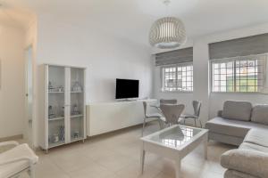 a living room with a couch and a tv at Casa Ricardo in Barbate