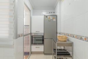 a white kitchen with a refrigerator and a stove at Casa Ricardo in Barbate
