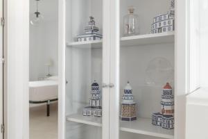 a white cabinet with shelves with lighthouses on it at Casa Ricardo in Barbate +13 photos