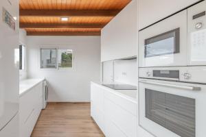 a kitchen with white appliances and a wooden ceiling at Casa Eloisa in Teror +24 photos