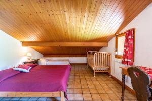 a bedroom with a bed and a wooden ceiling at Chalet de la Marmotte in Crest-Voland +100 photos