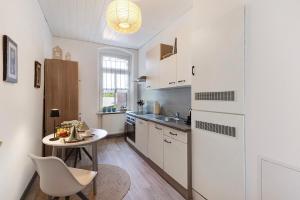 a kitchen with a table and a white refrigerator at Apartment City Leben in Nordhausen
