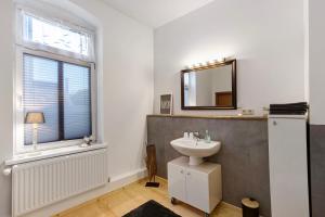 a bathroom with a sink and a mirror and a window at Apartment City Leben in Nordhausen