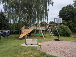 a wooden playground with a basketball hoop and a basketball hoopintend at Hof Grübler in Klipphausen
