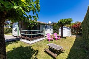 a small house with pink chairs and a picnic table at Chalet Yoya in Lanton