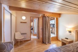 a bedroom with a bed and a desk and a window at Appt le grand Tetras D20 in Samoëns +17 photos