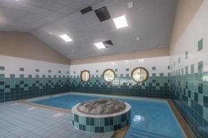 a swimming pool with a tub in a room at Appt le grand Tetras D20 in Samoëns